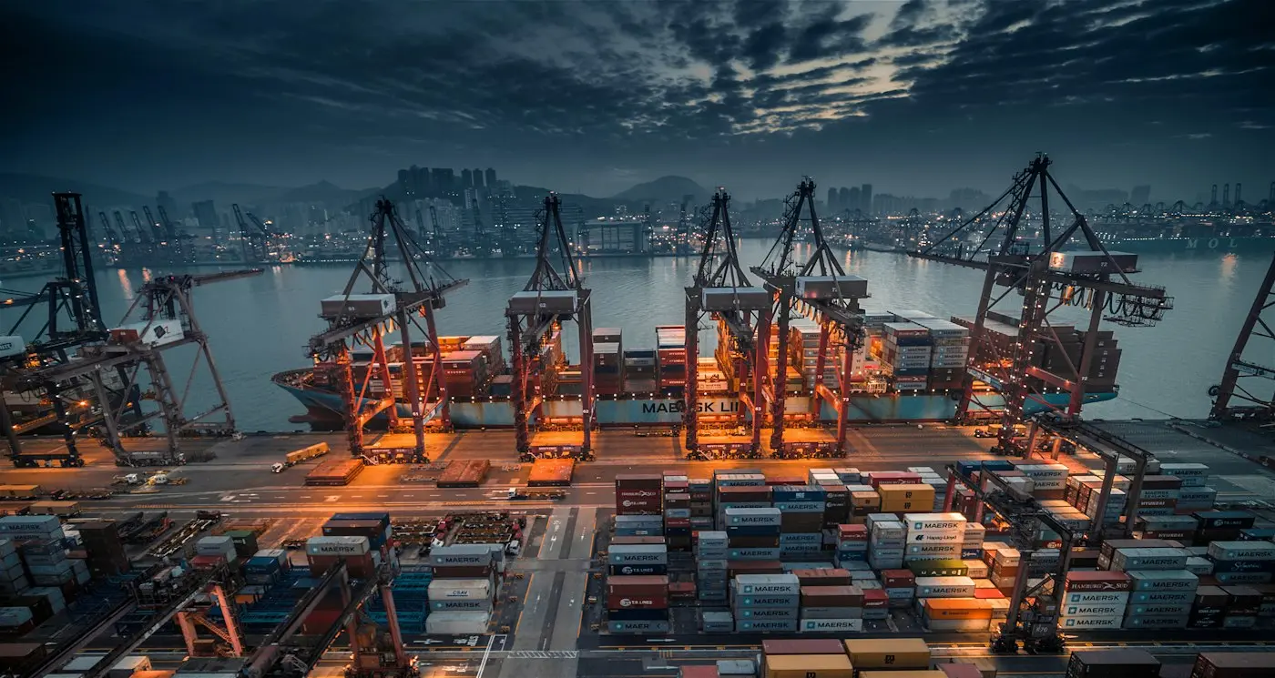 Container ship being loaded by cranes at a busy port