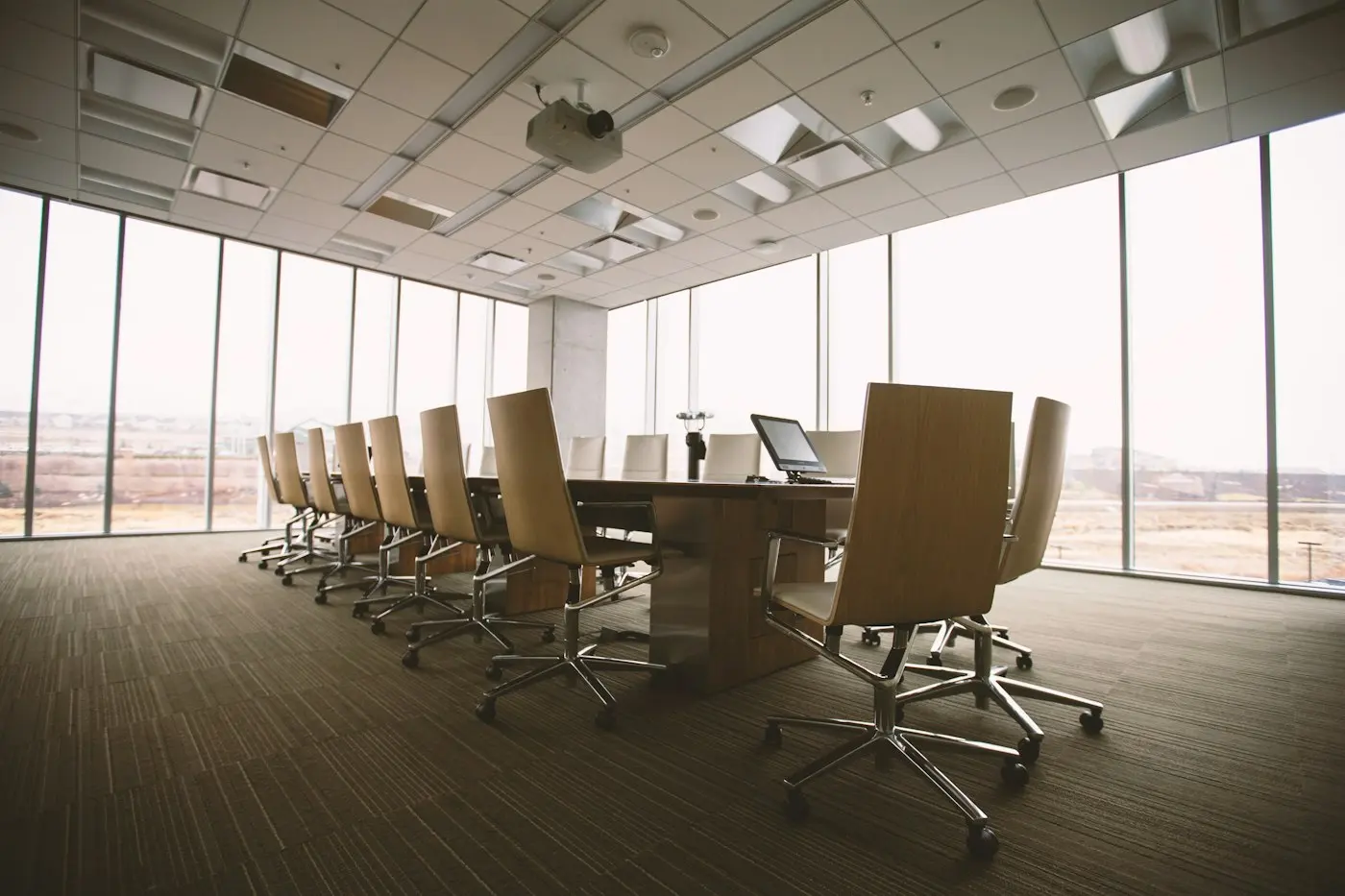 Empty boardroom with a long table and city views