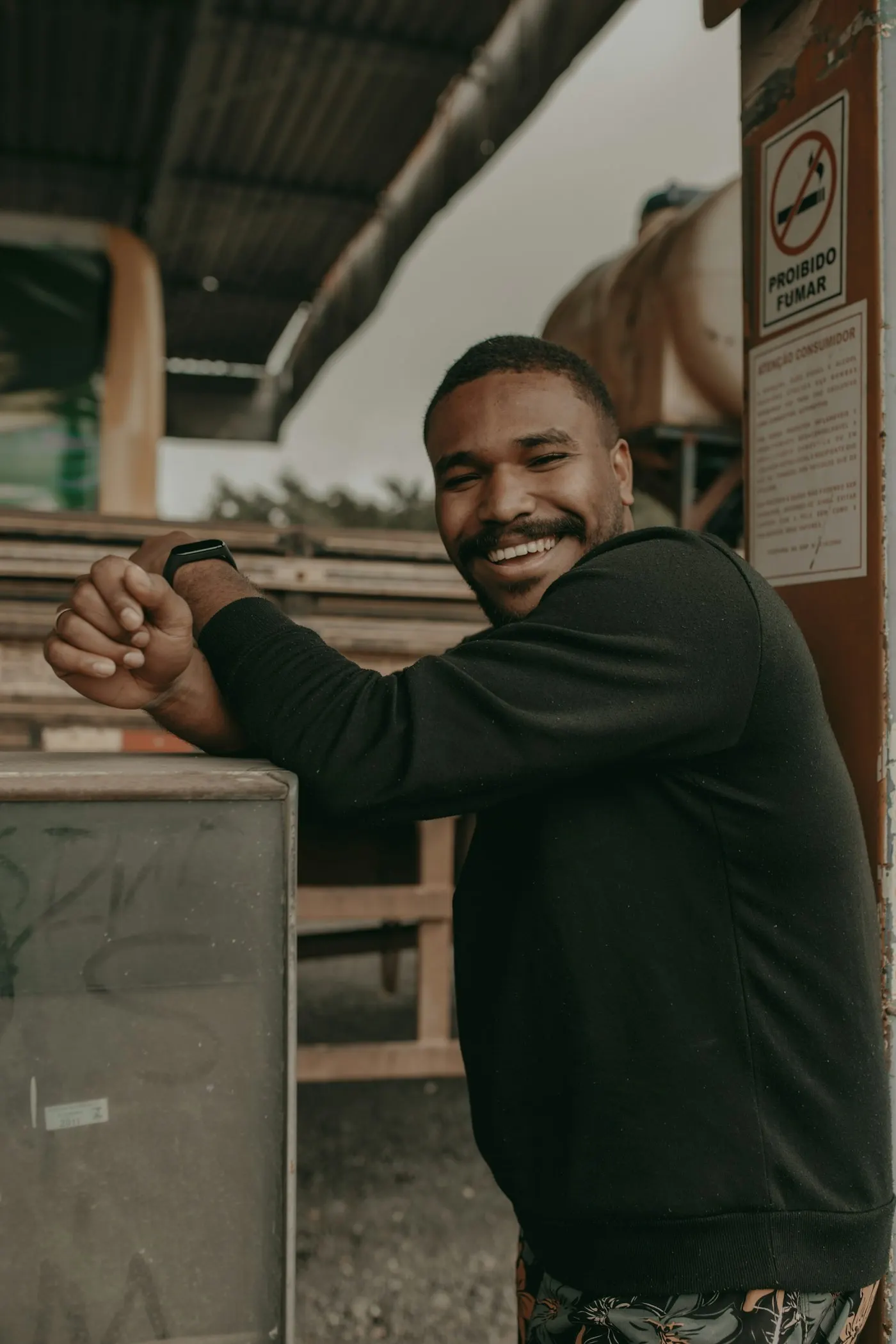 Smiling transport worker leaning on a loading dock