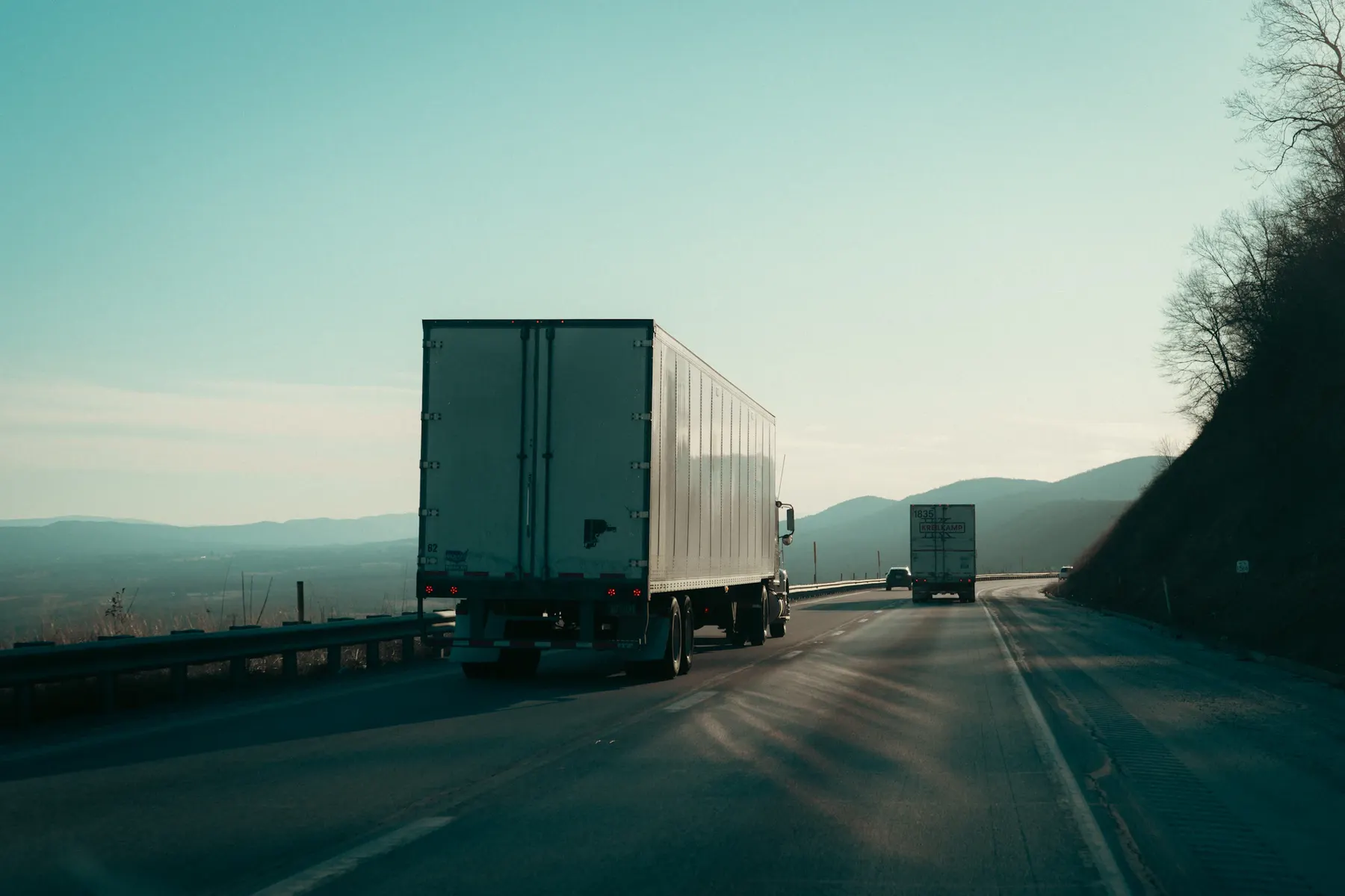 Semi-trailer trucks driving along a highway