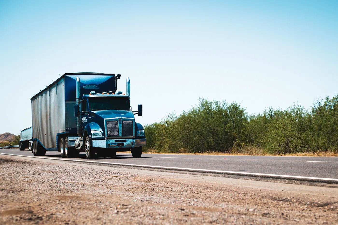 Blue truck and trailer on a regional road
