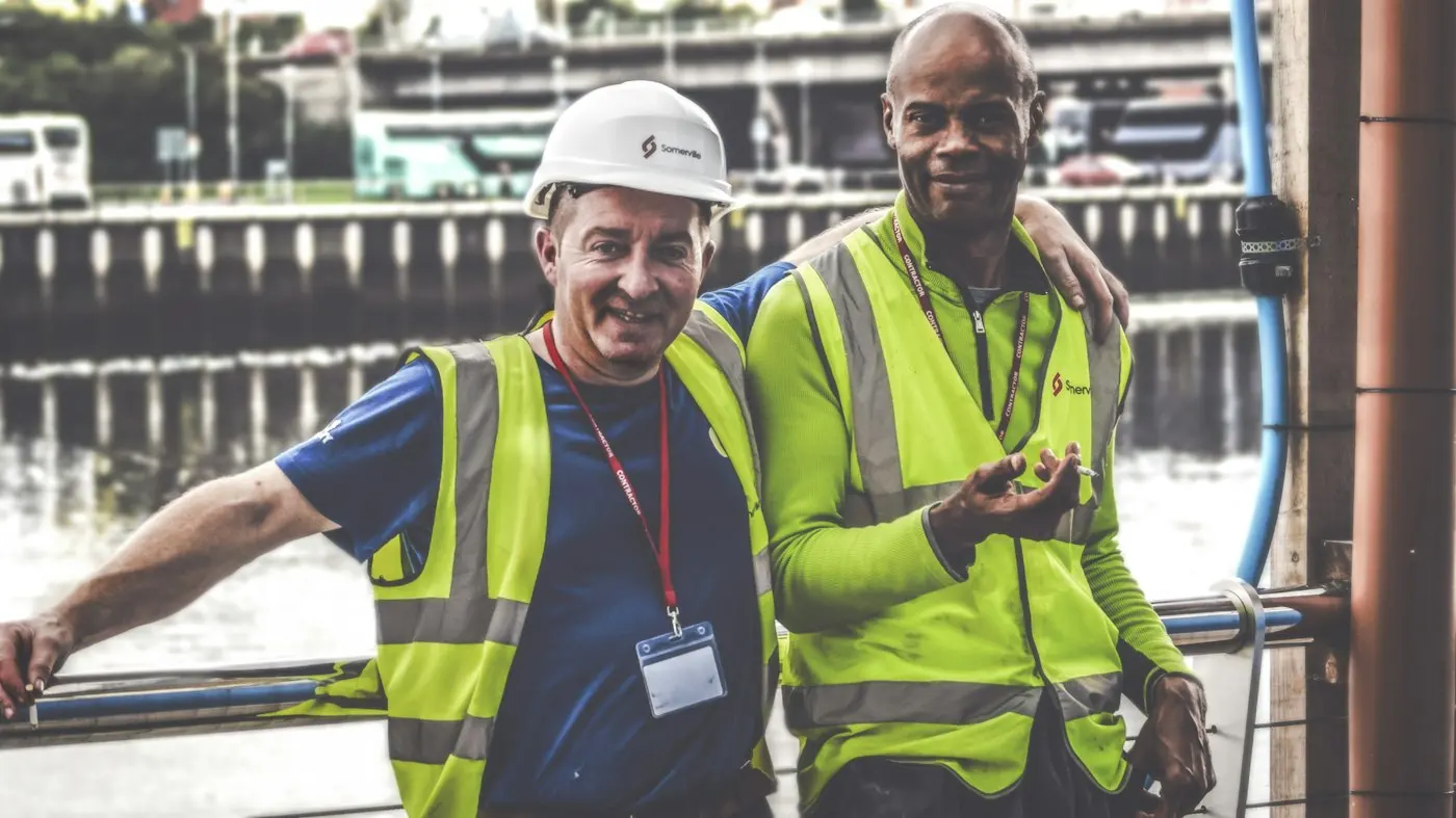 Two workers in hard hats on a building site